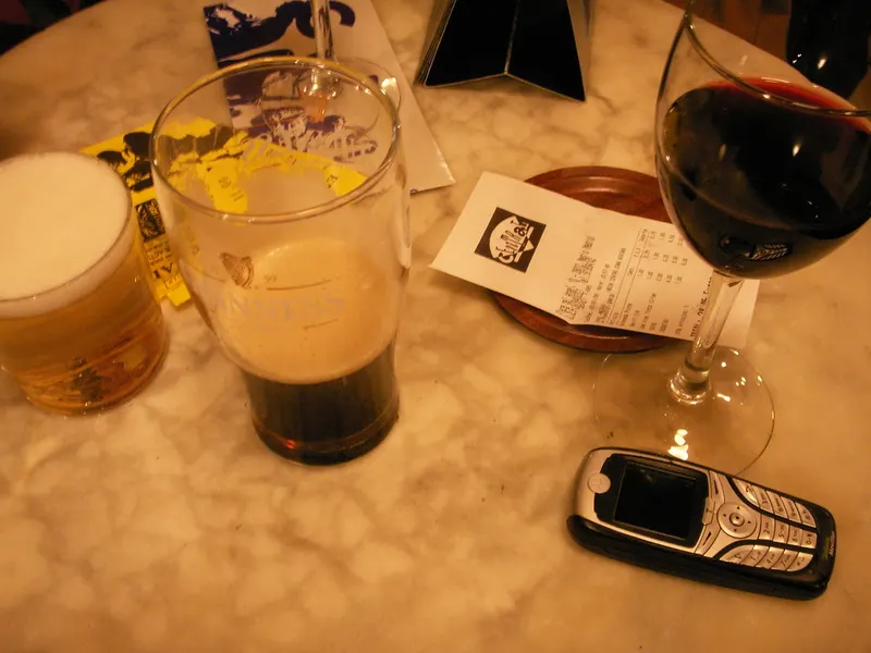 Caña, vaso de cerveza negra y copa de vino sobre una barra de mármol
