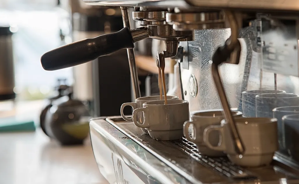 Cafetera de espresso sirviendo cafés en varias tazas